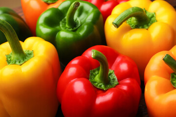 Fresh colorful bell peppers on table, closeup