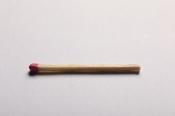One match with pink head on grey background, closeup