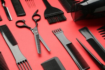 Different hairdresser's tools on red background, closeup