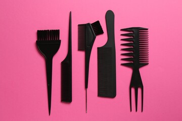 Different hairdresser's tools on pink background, flat lay