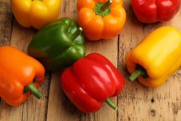 Fresh colorful bell peppers on wooden table, flat lay
