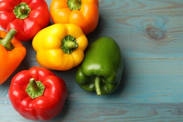 Fresh colorful bell peppers on blue wooden table, flat lay