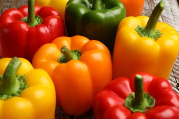 Fresh colorful bell peppers on table, closeup