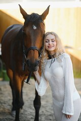 Obraz premium young woman in a dress with a horse