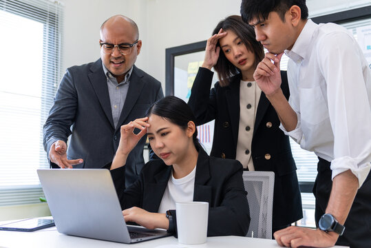 Diverse Asian business team stressed over financial statistics analysis problems. Group of business team meeting discussing various topics. Organizational concept in office.