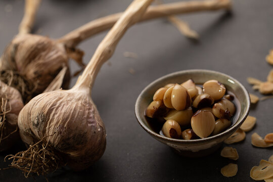 Garlic bulb with cloves on dark benchtop