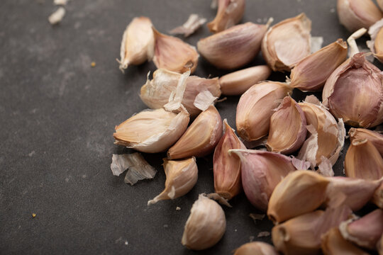 Garlic cloves on dark benchtop
