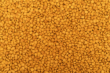 Food for animals background. Dry cat and dog food texture, pattern. Pet meal background close up. Dry food for pet dogs and cats. Dried pet food top view. Granules of good nutrition for dogs and cats.