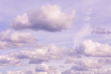 Cumulus clouds forming in purple-blue sky. Cloudscape photography. Atmospheric observation and weather concept. Design for wallpaper, poster, banner, postcard. Sky view with copy space.