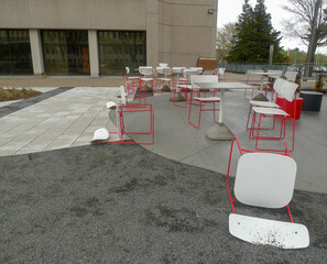 Chaises et tables rouges et blanches à l'extérieur d'un bâtiment de la ville.