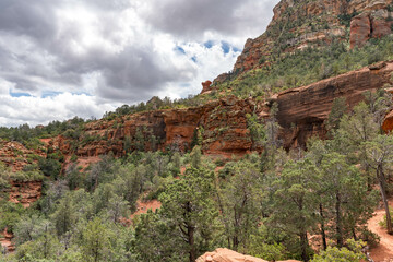 Sedona, Arizona, red rock formations and scenic landscapes under dramatic cloud-filled skies, capturing the natural beauty of the desert wilderness.