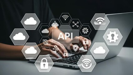 Person typing on a laptop with api icons overlayed on the screen in a dark studio setting