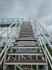 A staircase leads upward toward the open sky, symbolizing hope, dreams, and progress.