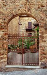San Gimignano, surrounded by ancient walls and vibrant courtyards filled with blooming flowers and medieval charm.