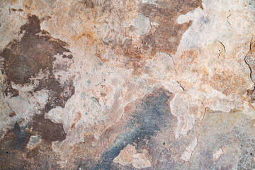 Rust and corrosion on weathered stone plate. Natural stone texture with earthy tones.