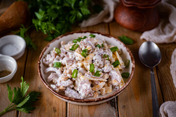 Hearty lunch: salad with vegetables and mayonnaise on a wooden table for lunch. Close-up
