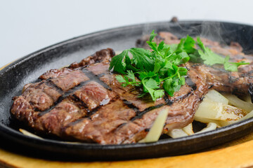 Sizzling Grilled Beef Steak with Fresh Cilantro on Hot Plate