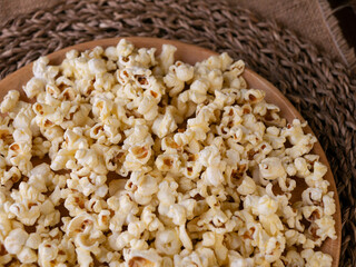 Butter salted popcorn on wooden table.