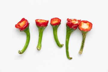 Hot red pepper tails on white background, cut parts of capsicum chilli pepper with seeds and green stalks