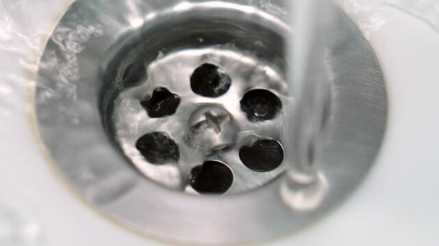 Kitchen water drain.
Ceramic wash basin and sewer drain for water macro.
Water flows into the drain