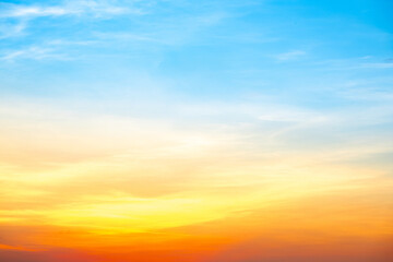 Fototapeta premium Sky,Beautiful sunset view, luxury soft gradient orange gold clouds and sunlight on the blue dramatic sky perfect for the background, morning, evening,Twilight, climate change,horizontal sunset photo