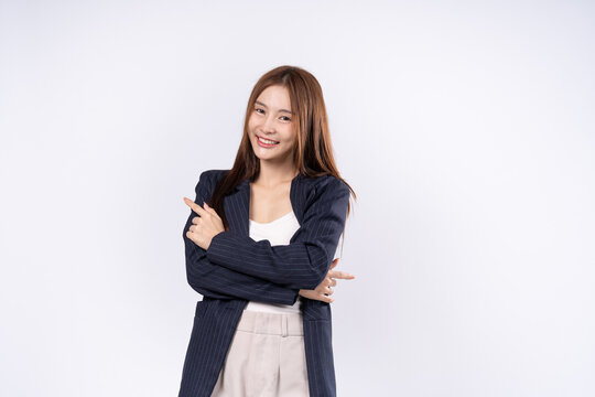 Asian woman in suit pose with arms crossed pointing fingers to both sides and smiling face photo in studio on white background - Powered by Adobe