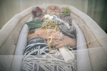 Elderly Woman in Coffin Holding Rosary..