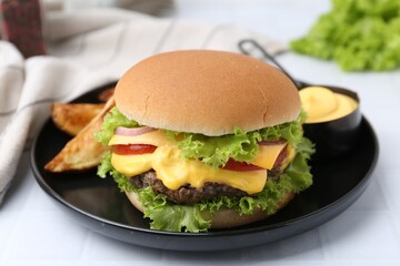 Tasty cheeseburger with sauce and potato wedges on white table, closeup