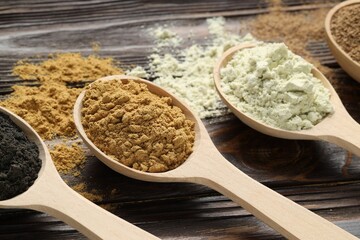 Different superfood powders and spoons on wooden table, closeup