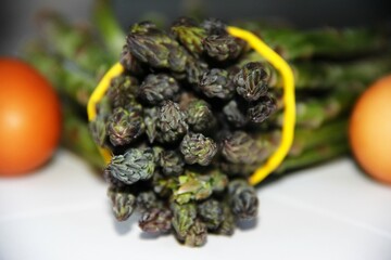 Fresh bunch of asparagus in a yellow rubber
