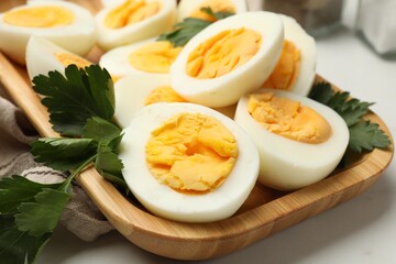 Boiled eggs and parsley on white table, closeup