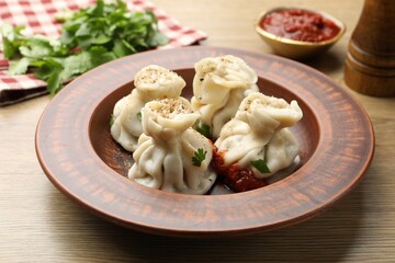 Tasty khinkali with spices on wooden table