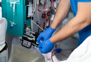 Doctor using modern medical equipment for blood transfusion procedure