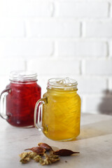 Colorful tropical fruit drinks with ice and garnishes in tall glasses