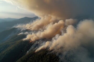 Fototapeta premium Smoke screen over the hills - top view (drone) where fire is moving through the forest, creating a dramatic atmosphere of natural disaster