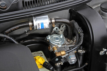 Gas equipment under the hood of the car. Gas reducer, gas filter and gas pipes for engine operation. Close-up of car engine parts.
