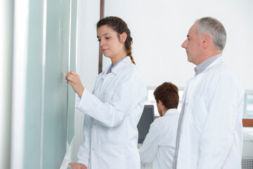 young woman writing on blackboard