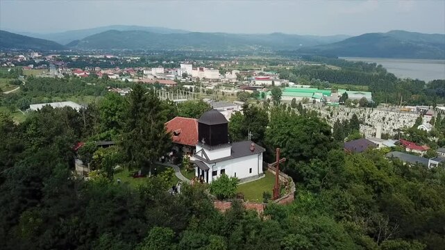 Aerial footage of Cetatuia Hermitage church on a hilltop with vegetations in Ramnicu Valcea, Romania
