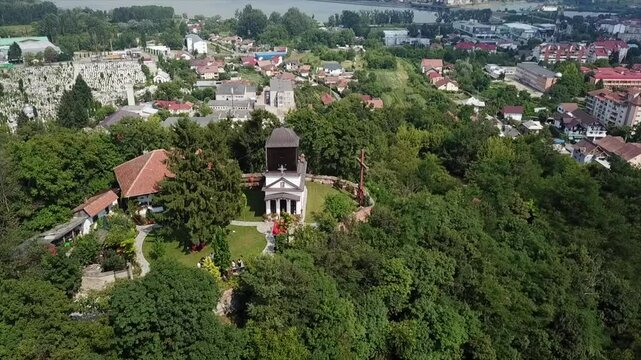 Aerial footage of Cetatuia Hermitage church on a hilltop with vegetations in Ramnicu Valcea, Romania