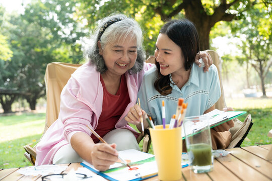 A senior mother and her daughter spend quality time together outdoors, sharing a tender moment filled with love and care. Their strong family bond reflects warmth and togetherness in every embrace
