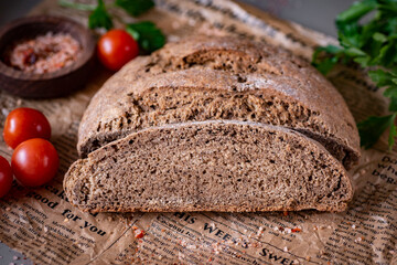 Slices of homemade rye bread on a newspaper. Homemade rye bread for lunch. Close-up