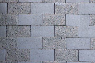 Clean gray stone wall with smooth and rough tiles