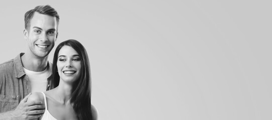 Monochrome black and white portrait - smile cute young couple, boyfriend girlfriend, beautiful woman, man, isolate gray grey background. Happy love concept. Banner image with free text space
