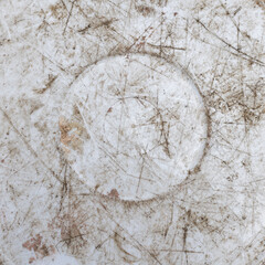 Scratched white plastic surface showing significant wear and tear outdoors