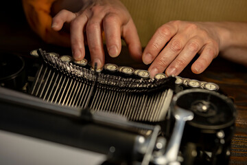 Hands creating stories on a vintage typewriter in a cozy workspace filled with nostalgia