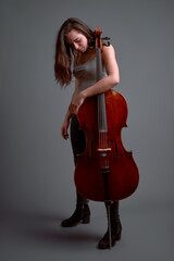Young musician holding a cello with a pensive expression