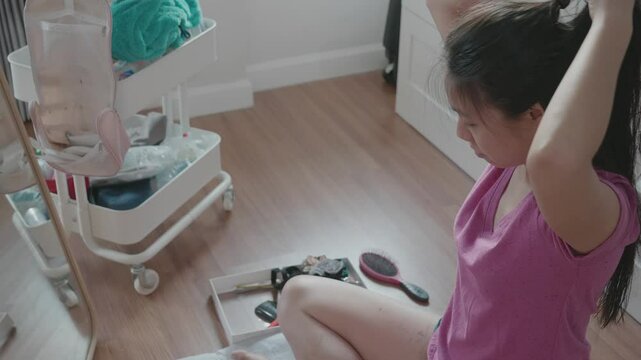 A woman sits on the floor in a cozy bedroom, surrounded by personal items. She appears focused as she prepares for her day, capturing the essence of a relatable morning routine and self-care.