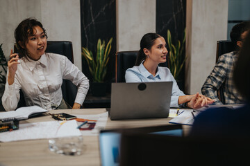 Multigenerational business colleagues engage in a productive meeting to strategize solutions for...