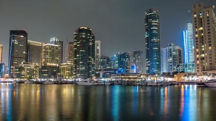 Obraz premium Dubai Marina towers and yacht in Dubai at night timelapse hyperlapse