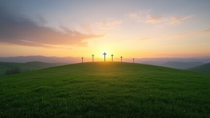 Obraz premium A serene landscape with a field of green grass and silhouetted crosses on a hill glowing in the warm light of a vibrant sunset